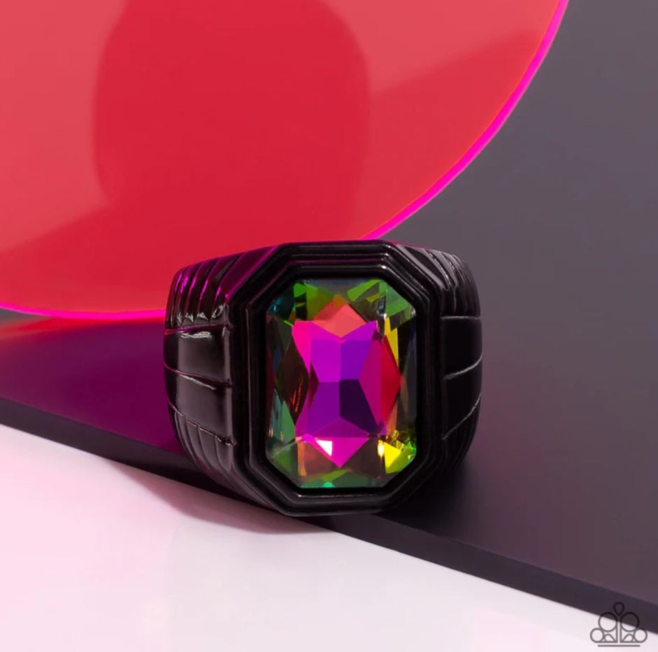 Cavalier Claim - Multi Color Urban Ring - Paparazzi Accessories - Featuring a regal emerald style cut, a glittery oil spill gem is pressed into a sleek black frame featuring a thick black band embossed in bold textures. Features a stretchy band for a flexible fit. Sold as one individual ring.