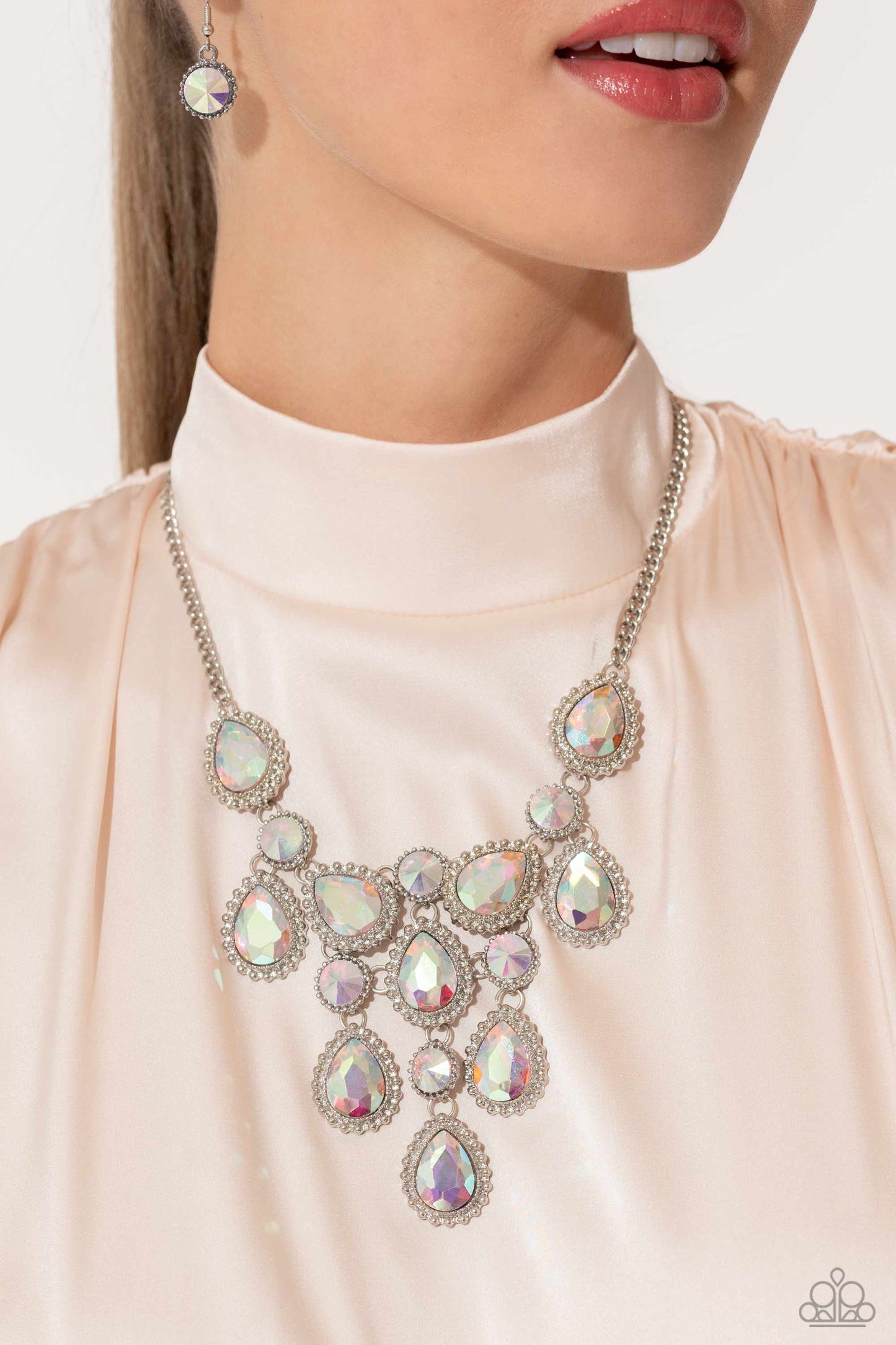 Dripping in Dazzle - Multi Iridescent Necklace - Paparazzi Accessories - An explosion of round, teardrop, and marquise-cut gems in varying sizes bordered by tactile silver studs cluster together to create a glittery iridescent showcase down the neckline. Featuring various shades of iridescence, each gem reflects light off of its faceted surface emitting further glitz and glam.