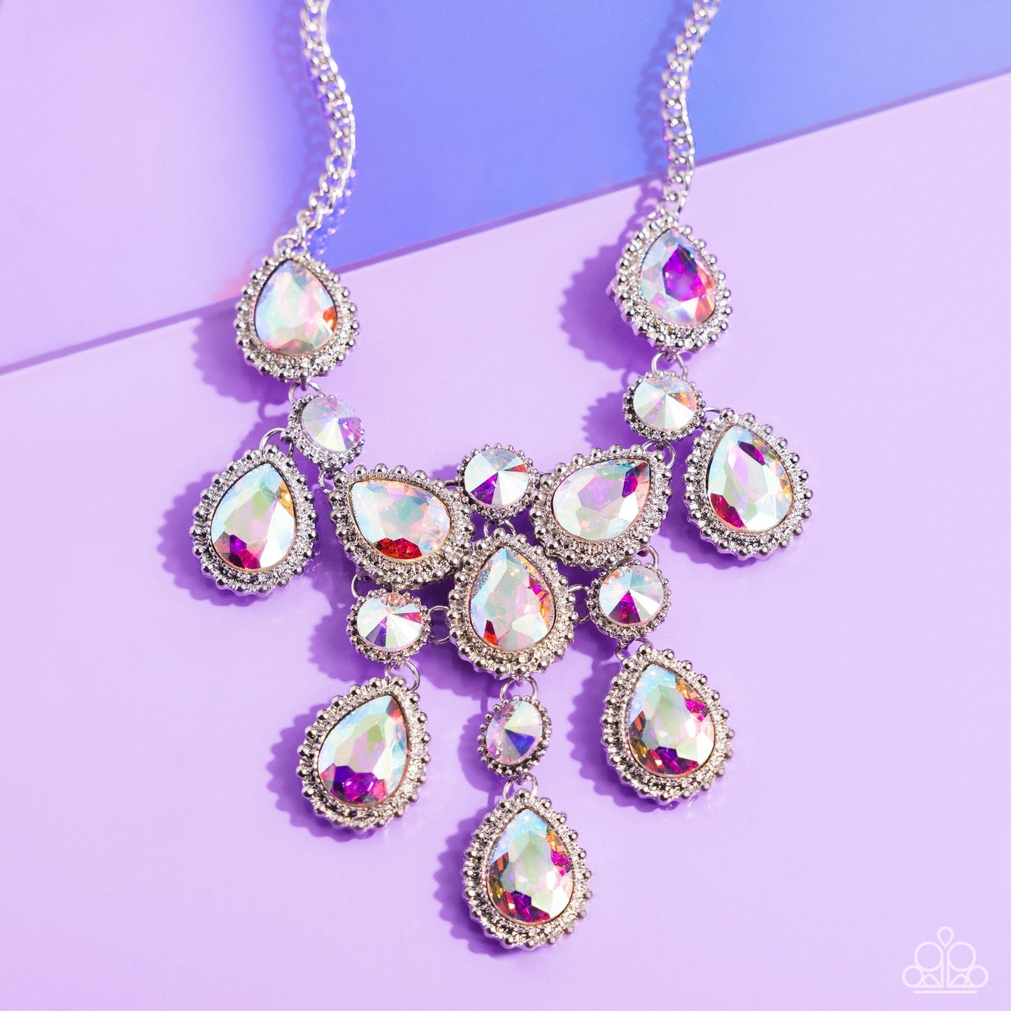 Dripping in Dazzle - Multi Iridescent Necklace - Paparazzi Accessories - An explosion of round, teardrop, and marquise-cut gems in varying sizes bordered by tactile silver studs cluster together to create a glittery iridescent showcase down the neckline. Featuring various shades of iridescence, each gem reflects light off of its faceted surface emitting further glitz and glam.