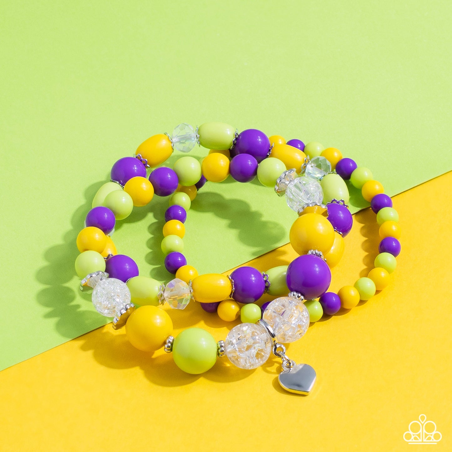 Heartfelt Haven - Multi Color Bracelet - Paparazzi Accessories - Love Bird, Empire Yellow, and purple beads, silver studs and accents, clear beads that have a shattered interior, and faceted beads with a reflective finish wrap around the wrist on elastic stretchy bands for a whimsical stack. Featured on one of the bracelets, a dainty silver heart pendant dangles for a heartfelt finish to the colorful design. Sold as one set of three bracelets.