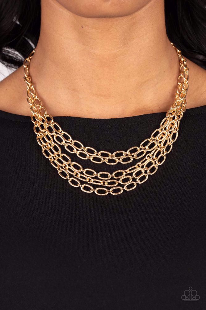 House of Chain - Gold Necklace - Paparazzi Accessories - A strand of textured gold links gives way to layers of identical chains that drape across the chest in a stunning industrial display. The textured links catch and reflect the light at every angle, adding breathtaking shimmer to the monochromatic design. Features an adjustable clasp closure. Sold as one individual necklace.