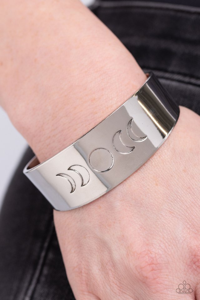 Lunar Effect - Silver Cuff Bracelet - Paparazzi Accessories - The phases of the moon are engraved across the front of a thick, shiny, silver cuff creating an effortlessly celestial statement piece.