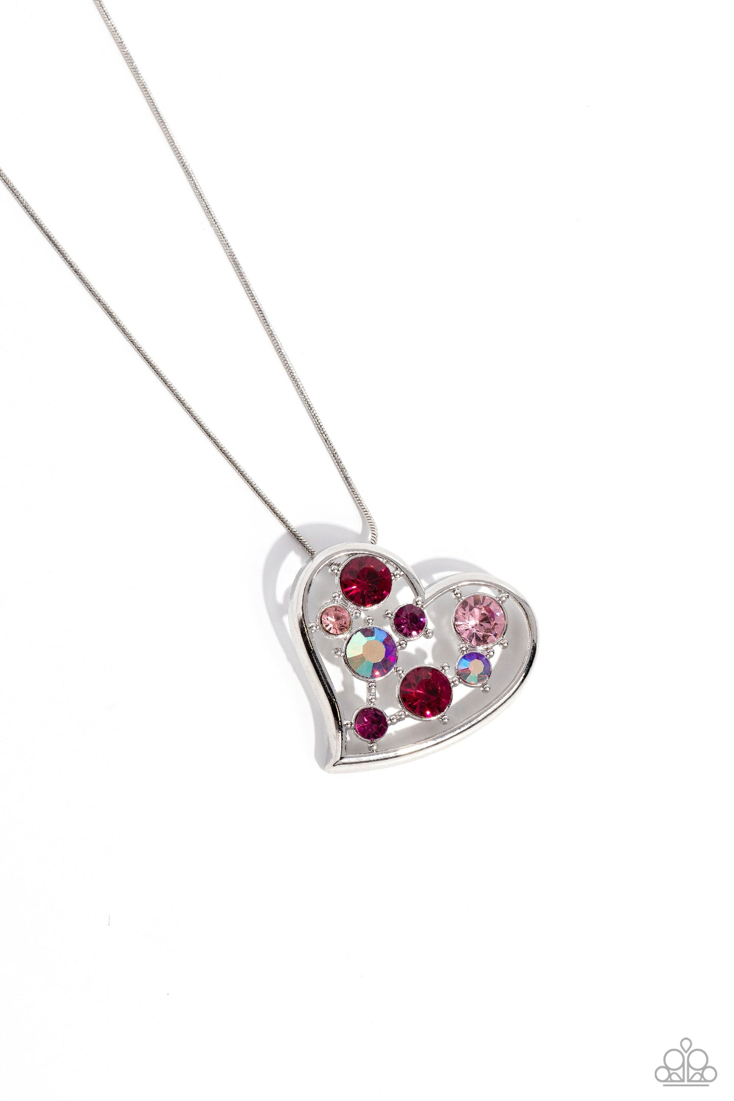 Romantic Recognition - Pink Heart Necklace - Paparazzi Accessories - Cascading from a silver snake chain, a thick, sideways sliding-heart silhouette falls down the neckline for a romantic statement. Haphazardly scattered across the inside of the heart frame, a glittery collection of pink and iridescent fuchsia round rhinestones in varying sizes shimmer and shine for a refined finish.