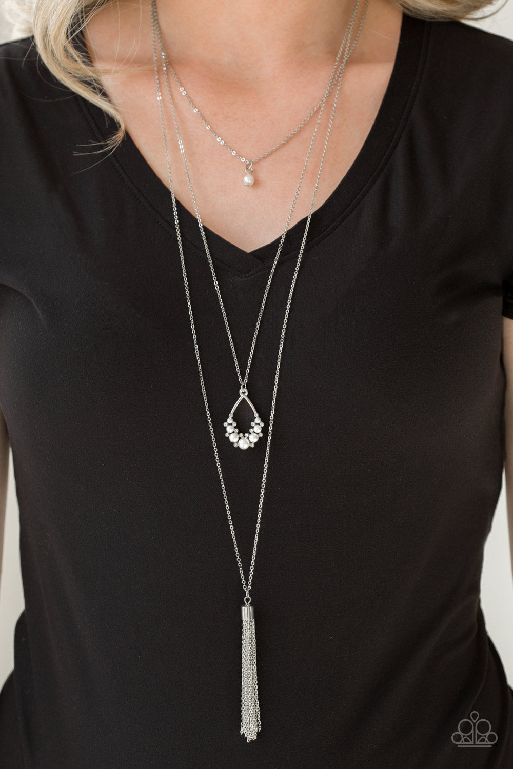 Be Fancy - White Pearl and Silver Necklace - Paparazzi Accessories - A solitaire white pearl swings from the uppermost chain, giving way to a teardrop pendant and shimmery silver chain tassel. Dainty white rhinestones and white pearls collect at the bottom of the centermost pendant for a glamorous finish.