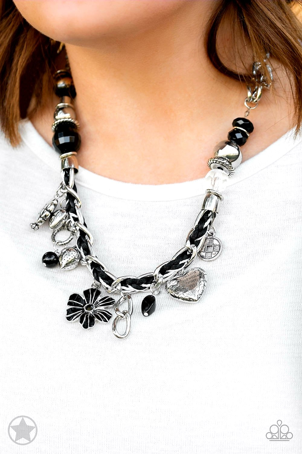 Charmed, I Am Sure Black Necklace - Paparazzi Accessories - Black and ivory cording is braided through a chunky silver chain. A unique variety of charms decorate the piece including a delicate flower and a heart. Heart is inscribed with the phrase "With All My Heart"on one side and a short bible verse on the other that reads, "Love the Lord thy God with all your heart. Luke 10:27." Features an adjustable clasp closure.Includes necklace and one pair of matching earrings.