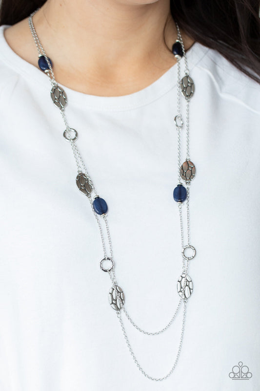 Cobble Creeks - Blue and Silver Fashion Necklace - Paparazzi Accessories - Textured silver links alternate between glassy blue accents and cobblestone patterned silver discs along two shimmery chains, creating whimsical layers across the chest. Features an adjustable clasp closure.