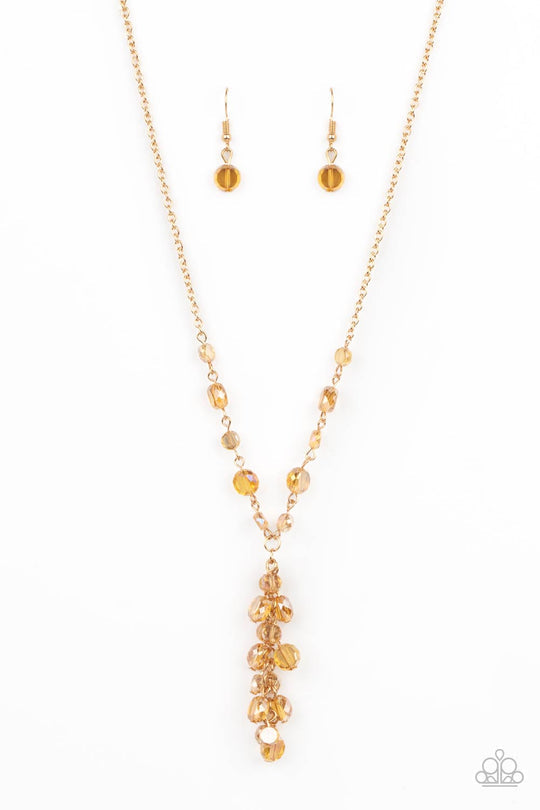 Cosmic Charisma - Gold Iridescent Necklace - Paparazzi Accessories - Dipped in a rainbow iridescence, a faceted collection of golden crystal-like beads delicately links below the collar. A tassel of matching beads cascades from the center, creating a stellar extended pendant.