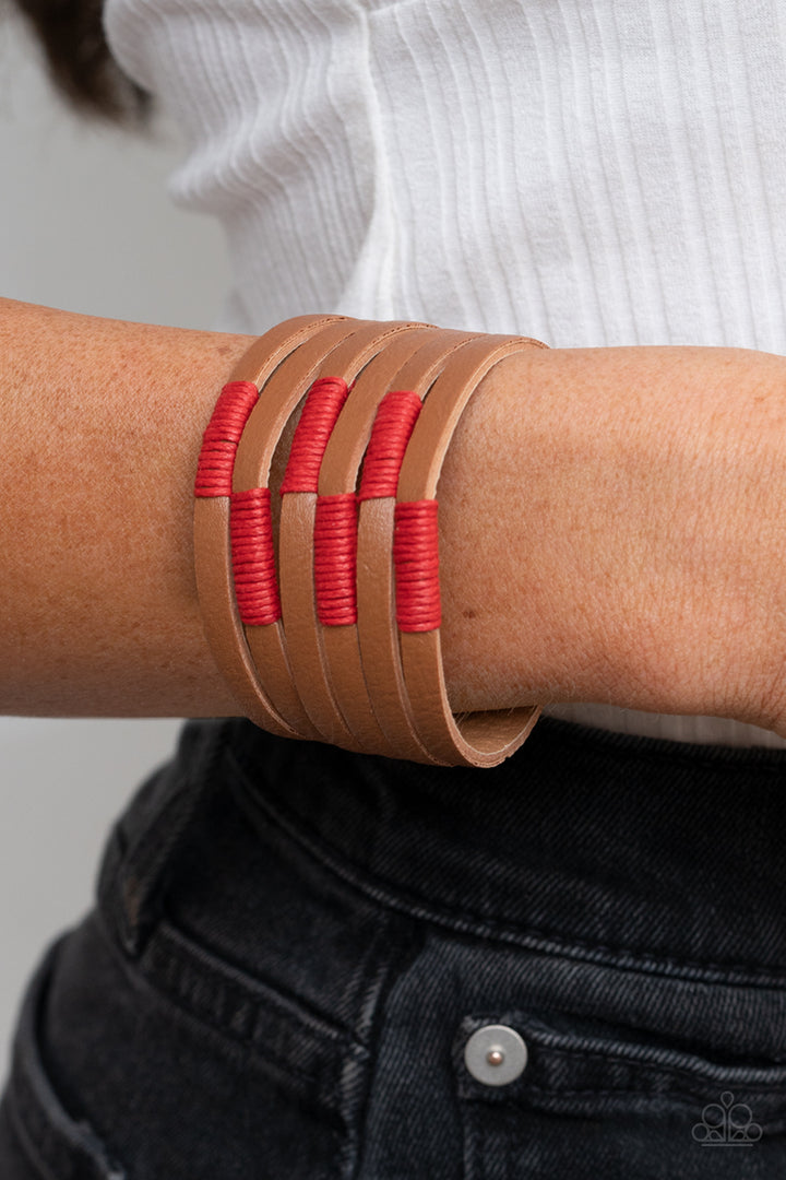 Country Colors - Red and Brown Leather Snap Bracelet - Paparazzi Accessories - A brown leather band has been spliced into layered rows that wrap around the wrist. Red threaded accents wrap around the leather strips, creating a colorfully rustic display. Features an adjustable snap closure. Sold as one individual bracelet.