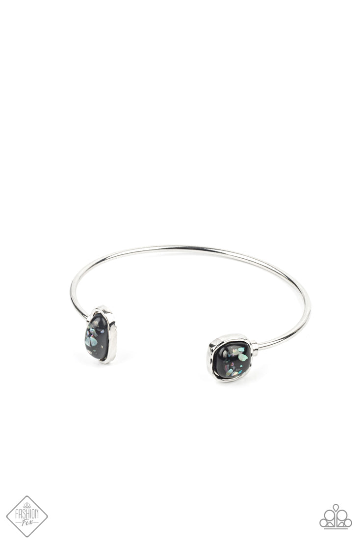 Dont BEAD Jealous - Black and Silver Cuff Bracelet - Paparazzi Accessories - Iridescent shell-like pieces are encased inside two mismatched glassy black beads at both ends of a dainty silver open-faced cuff. The shimmery beads are encased in imperfectly hammered silver frames, adding a whimsical fashion bracelet.