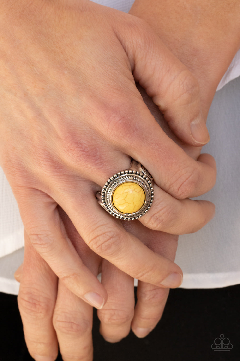 Evolutionary Essence - Yellow and Silver Ring - Paparazzi Accessories -
A round yellow stone is pressed into the center of a studded silver frame embossed with rustic swirls, creating a trendy tribal inspired centerpiece atop the finger. Features a stretchy band for a flexible fit. Sold as one individual ring.