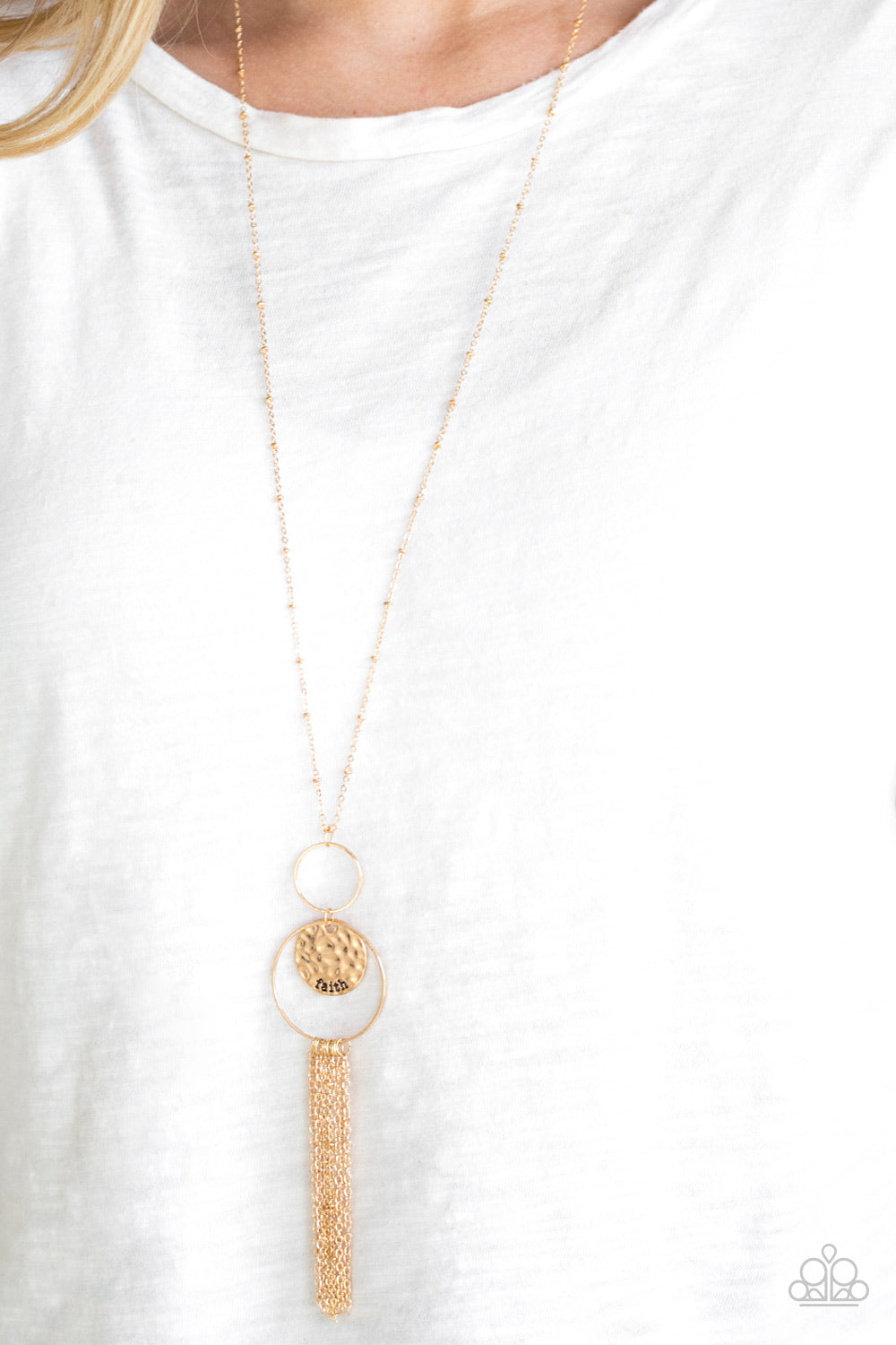 Faith Makes All Things Possible - Gold Necklace - Paparazzi Accessories - A delicately hammered gold disc is stamped in the inspirational word, "faith" and suspended from a double-hooped pendant at the bottom of an elongated gold satellite chain. A gold tassel swings from the bottom of the shimmery palette for a whimsical finish. Features an adjustable clasp closure. Sold as one individual necklace.