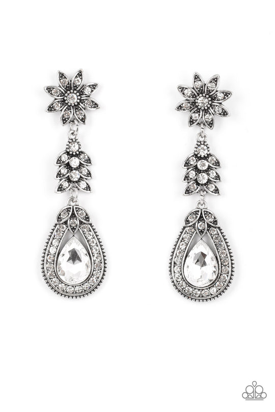 Floral Fantasy - Silver and White Earrings - Paparazzi Accessories - Dotted in dainty white rhinestones, a studded silver flower gives way to a leafy frame that is delicately suspended above a decorative white rhinestone dotted teardrop frame. An oversized teardrop gem seemingly floats inside the center of the lowermost frame, adding timeless dazzle to the floral fairytale. Earring attaches to a standard post fitting. Sold as one pair of post earrings.
