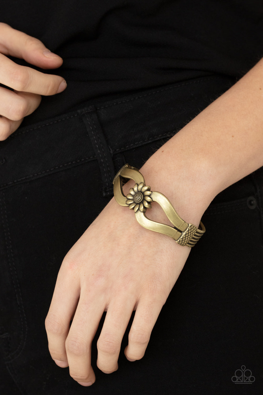 Let A Hundred SUNFLOWERS Bloom - Brass Cuff Hinged Bracelet - Paparazzi Accessories - Antiqued brass ribbons loop out from a decorative brass sunflower that attaches to a ribbed brass frame, creating a cuff-like bangle around the wrist. Features a hinged closure. Sold as one individual fashion bracelet.