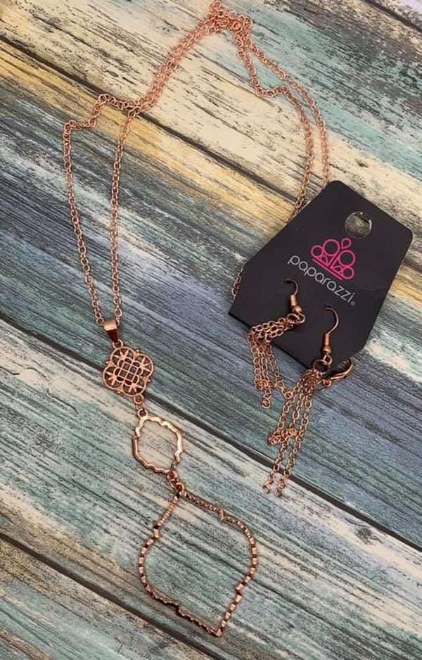 Marrakesh Mystery - Copper Fashion Necklace - Paparazzi Accessories - Glistening copper diamond shaped pendants give way to a mandala-like pendant swirling with filigree detail at the end of a lengthened copper chain for a whimsical look. Features an adjustable clasp closure.