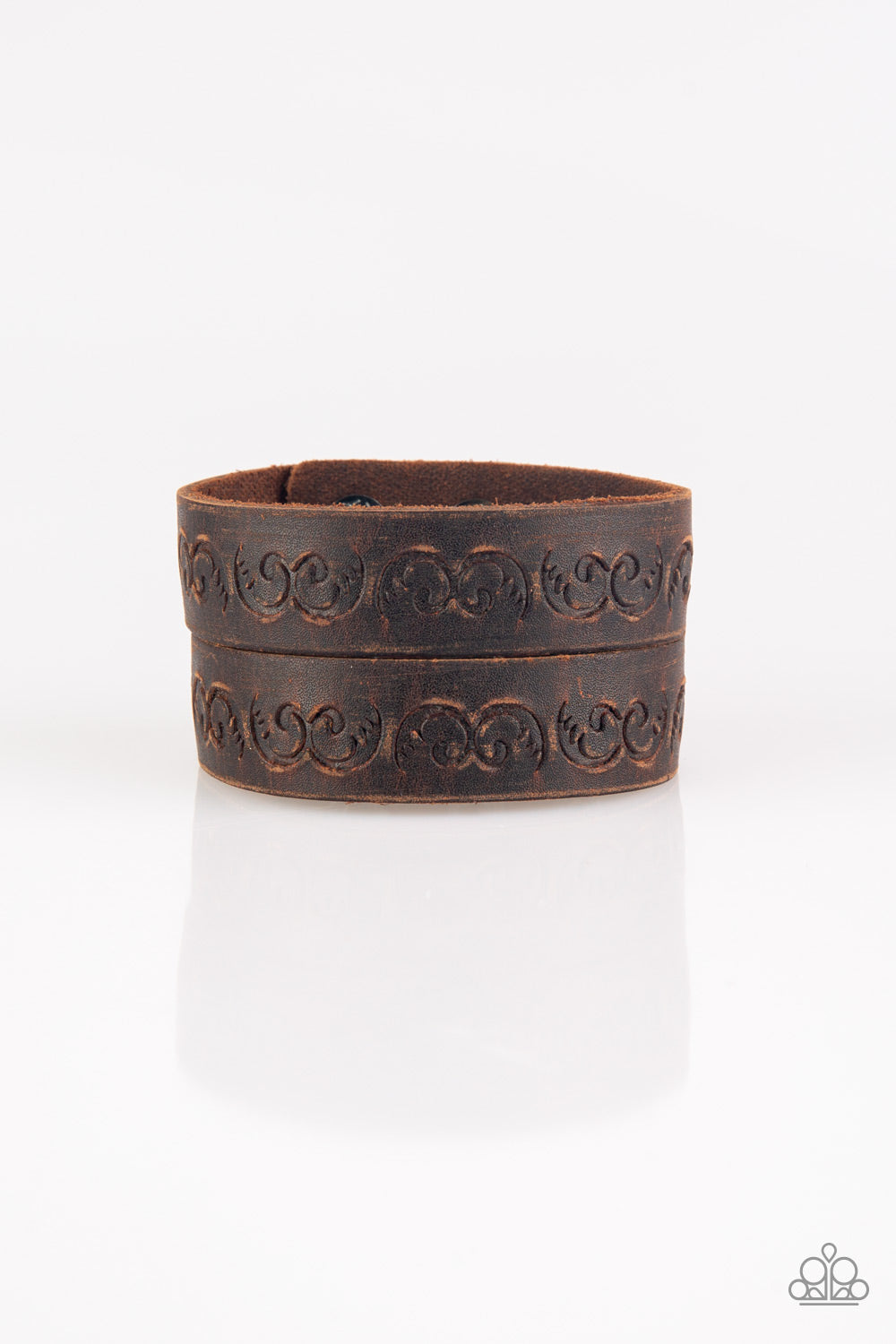 Ride and Wrangle - Urban Brown Snap Bracelet - Paparazzi Accessories - Split down the center, a distressed brown leather band has been stamped in a traditional western pattern for a rustic look. Features an adjustable snap closure. Sold as one individual bracelet.