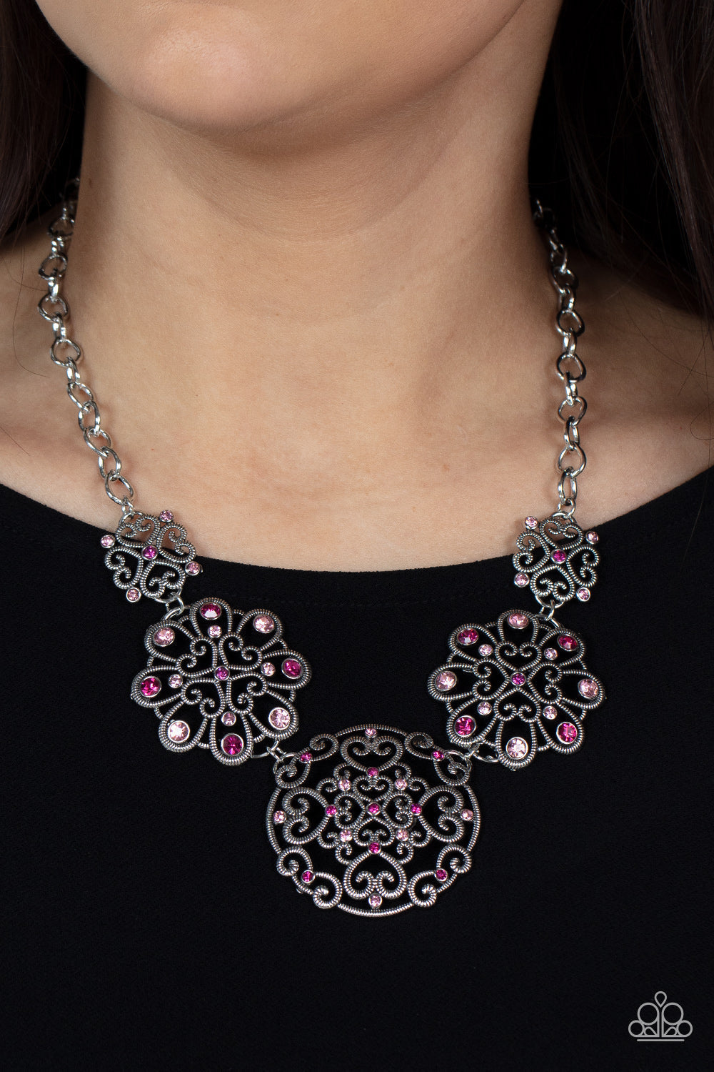 Royally Romantic - Pink and Silver Necklace - Paparazzi Accessories - Spiraling with heart shaped filigree patterns, a mismatched collection of silver mandala-like frames delicately link below the collar. A smattering of dark and light pink rhinestones adorn the ornate frames, adding a spritz of glitter to the regal display. Features an adjustable clasp closure. Sold as one individual necklace.
