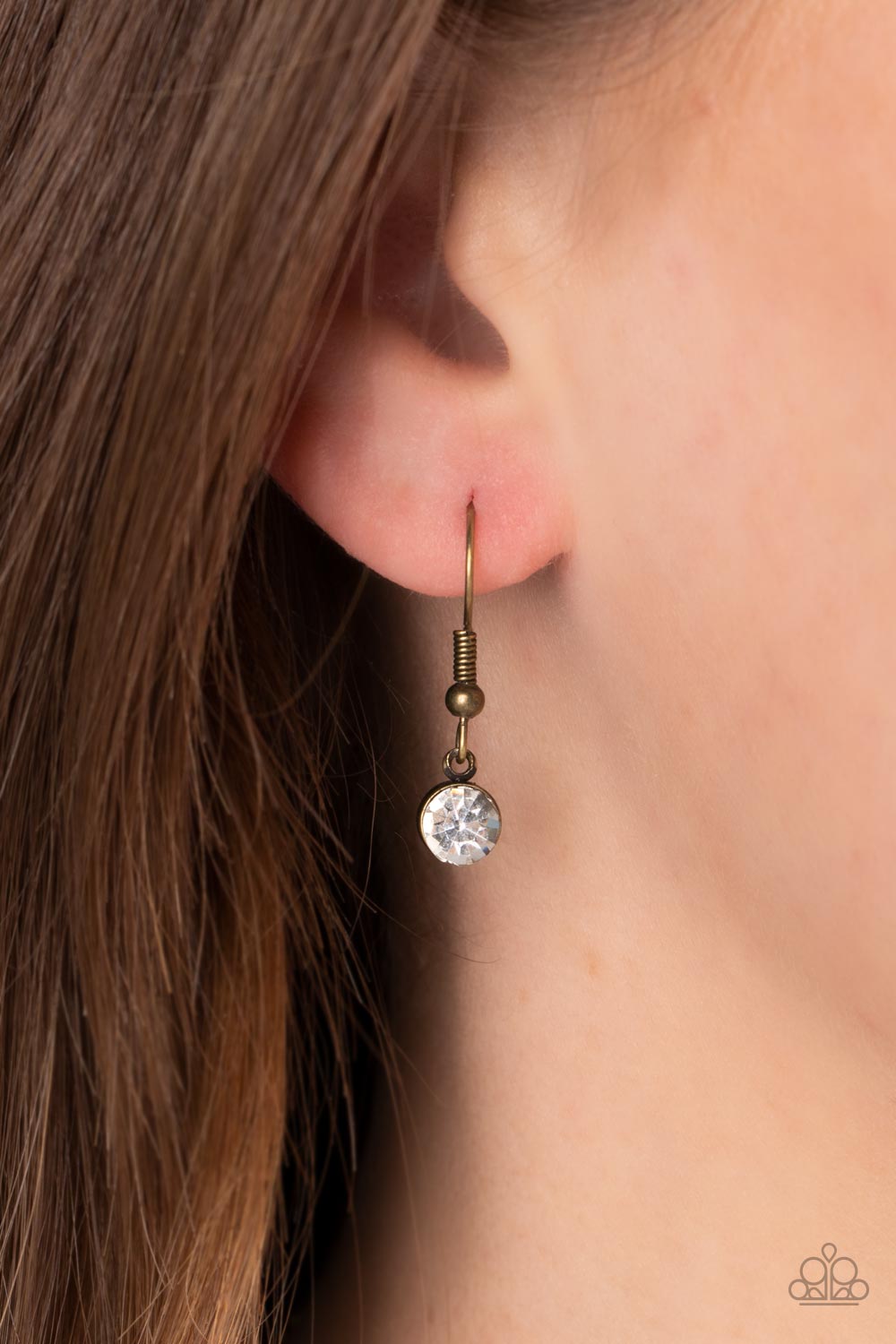 Surrealist Sparkle - Brass Necklace - Paparazzi Accessories - A warped brass frame gently folds around an oversized white teardrop gem center, resulting in a gritty yet glamorous pendant at the bottom of a lengthened brass chain.