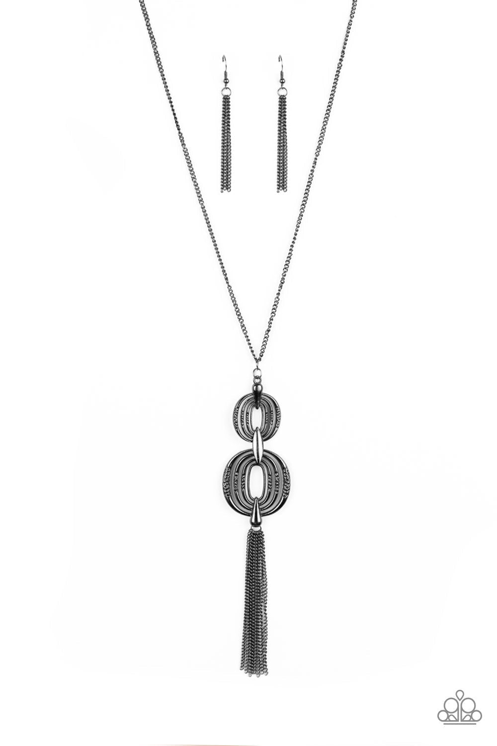 Timelessly Tasseled - Black Necklace - Paparazzi Accessories - Delicately hammered in sections of shimmer, gunmetal circular frames stack into a bold pendant at the bottom of a lengthened gunmetal chain. A shimmery gunmetal tassel swings from the bottom of the stacked pendant for a casual finish. Features an adjustable clasp closure.