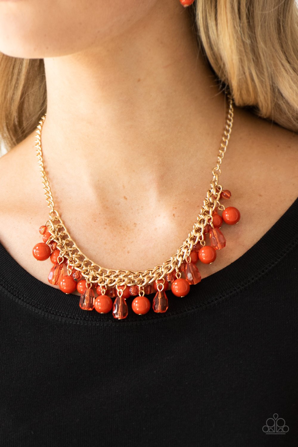 Tour de Trendsetter - Orange and Gold Necklace - Paparazzi Accessories - Varying in shape, glassy and polished orange beads swing from the bottom of interlocking gold chains. Crystal-like teardrops are sprinkled along the colorful beading, creating a flirtatious fringe below the collar.