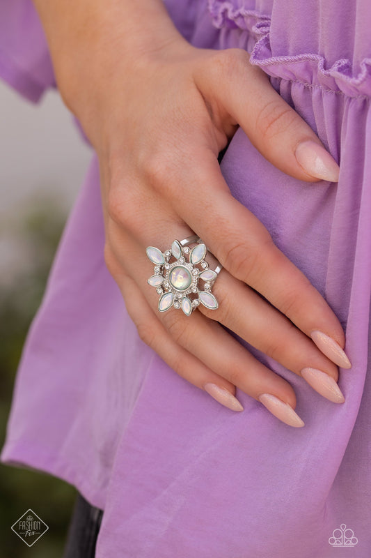 A Summer Spell - Green and Silver Ring - Paparazzi Accessories - Marquise-cut beads in an ethereal, opalescent shade of green fan out around a rounded center of the same hue to create a floral-inspired design. White rhinestones dot the radiating silver frames that support the structure, introducing a hint of sparkle that magnifies the reflective sheen of the glossy beads. Features a stretchy band for a flexible fit. Sold as one individual ring.