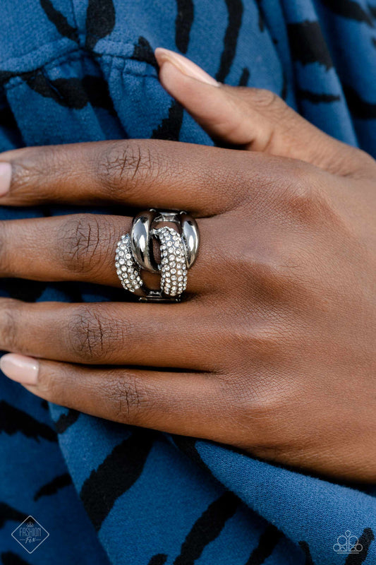 Alluring Ace - Black Gunmetal Ring - Paparazzi Accessories - A pair of oversized, rounded chain links interlock across the top of the finger, creating an unflinching statement piece. One gunmetal link is coated in sparkling white rhinestones, while the other emits a radiant sheen from its polished surface, resulting in a flawless mashup of grit and glitz.