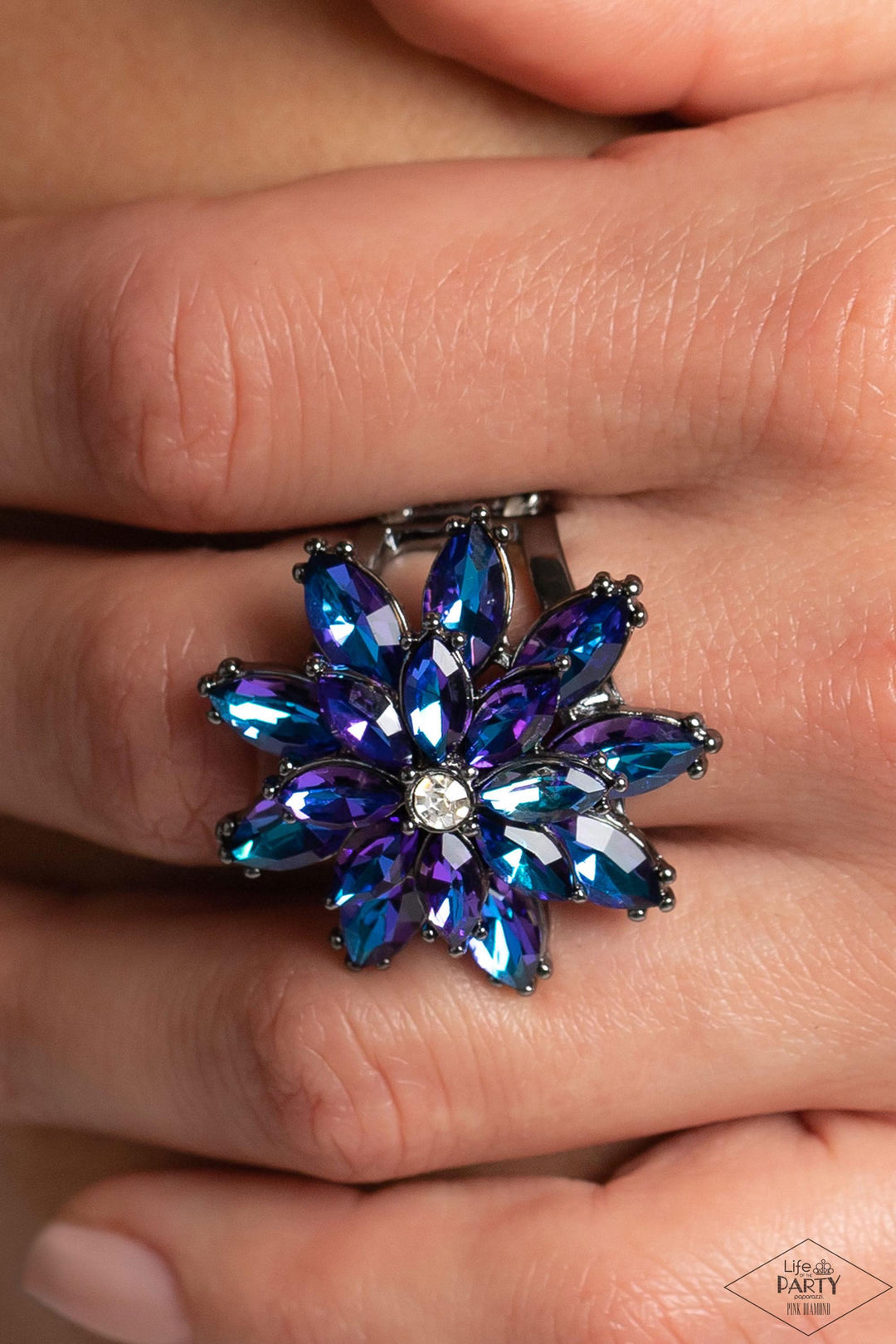 Am I GLEAMing? Multi Blue Iridescent Ring - Paparazzi Accessories -Glittery blue iridescent rhinestone petals stack into a glamorous floral frame atop the finger, creating a blinding centerpiece. Features a stretchy band for a flexible fit. Due to its prismatic palette, color may vary.

Sold as one individual ring.