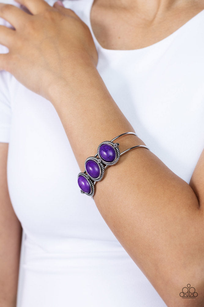 Badlands Backdrop - Purple Bracelet - Paparazzi Accessories - A trio of purple stones, pressed into twisted and textured silver frames graces the top of an airy silver cuff. Dainty floral details separate each stony frame, adding a floral finish to the design.