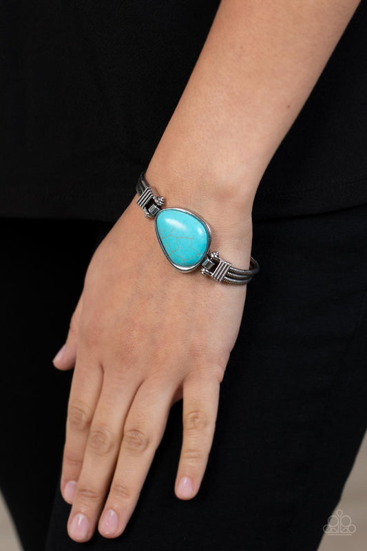 Badlands Bounty - Blue Turquoise and Silver Bracelet - Paparazzi Accessories - Textured silver frames hold in place rows of silver rounded snake chain around the wrist. An asymmetrical turquoise stone pendant adorns the center of the earthy compilation, adding a rustic pop of color. Features a fold over clasp closure. Sold as one individual bracelet.