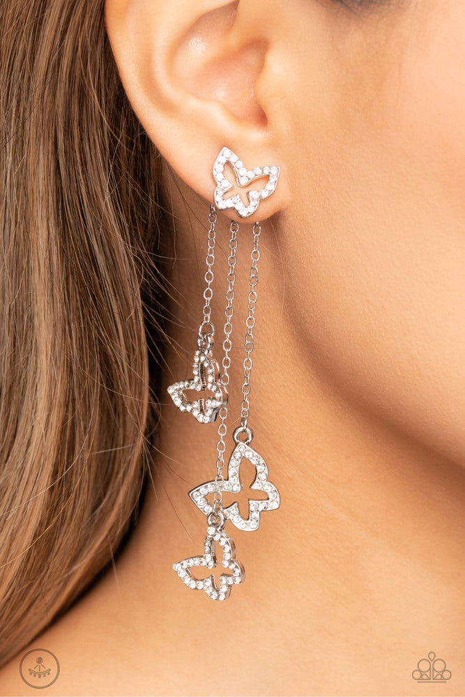 Boisterous Butterfly - White and Silver Earrings - Paparazzi Accessories - Cascading from a solitaire, rhinestone-encrusted butterfly, a trio of butterfly silhouettes in varying sizes with a similar sparkle attaches to a double-sided post as it cascades from dainty silver chains for an eye-catching flutter below the ear.