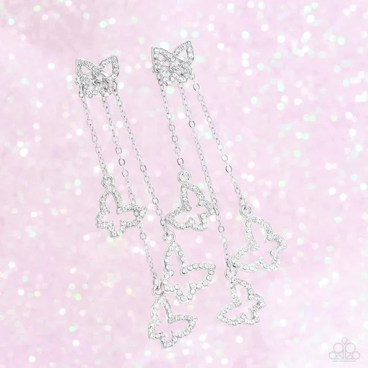 Boisterous Butterfly - White and Silver Earrings - Paparazzi Accessories - Cascading from a solitaire, rhinestone-encrusted butterfly, a trio of butterfly silhouettes in varying sizes with a similar sparkle attaches to a double-sided post as it cascades from dainty silver chains for an eye-catching flutter below the ear.