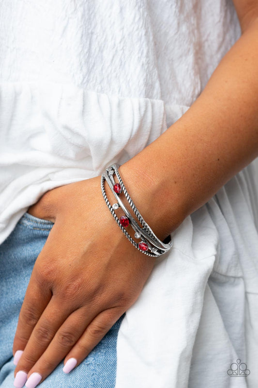 Bonus Bling - Red and Silver Bracelet - Paparazzi Accessories - Bordered in rustic silver bars, a sparkly collection of glassy white and teardrop and oval red rhinestones are sporadically sprinkled across the silvery crisscrossed layers of a bangle-like bracelet, resulting in a versatile sparkle around the wrist. Features a hinged closure.