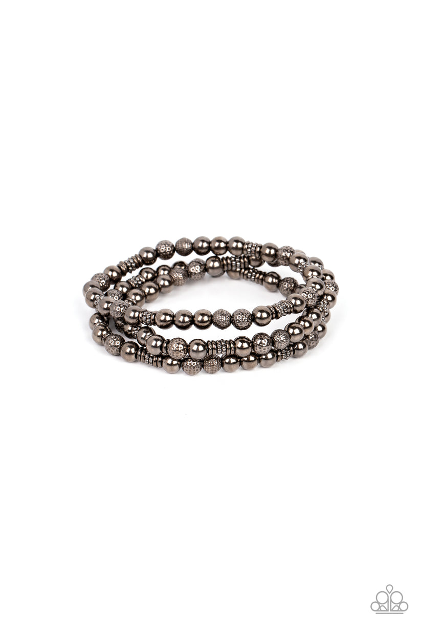 Boundless Boundaries - Gunmetal Black Bracelet - Paparazzi Accessories - A gritty collection of smooth, studded, and textured gunmetal beads are threaded along stretchy bands around the wrist, creating dainty layers. Sold as one set of three bracelets.