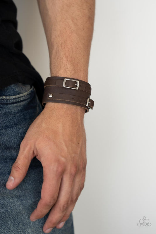 Bronco Bustin Buckles - Brown Urban Bracelet - Paparazzi Accessories - A pair of brown leather buckles are buckled in place across the front of a rustic brown leather band for a seasonal look. Features an adjustable snap closure. Sold as one individual bracelet.