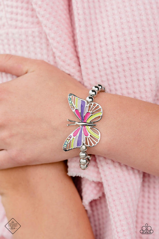 Cant FLIGHT This Feeling - Multi Color Butterfly Bracelet - Paparazzi Accessories - This elastic stretchy band has sleek silver beads wraps around the wrist. Oversized silver butterfly, with baby pink, Fuchsia Fedora, purple, and Love Bird details is sprinkled with dainty multicolored and iridescent rhinestones across its wings, for a dramatically dazzling finish. Sold as one individual bracelet.