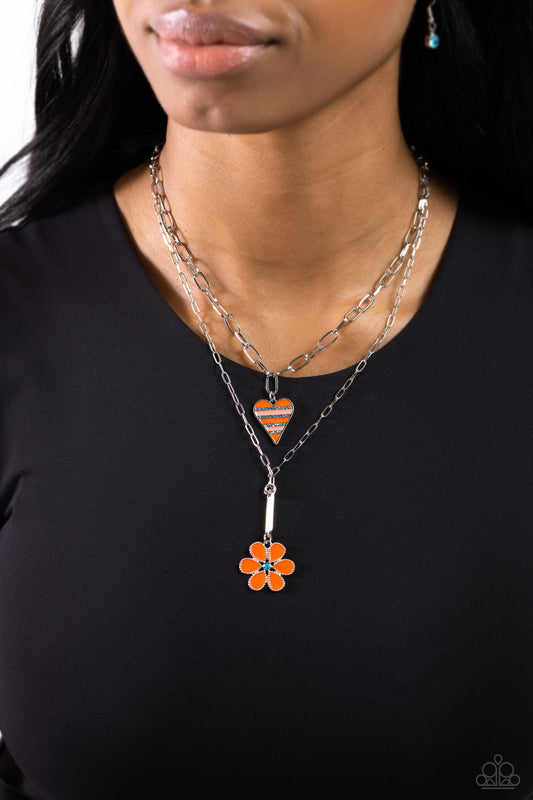 Childhood Charms - Orange and Silver Necklace - Paparazzi Accessories - Featuring dainty blue rhinestones, an elongated silver heart charm with stripes of Burnt Orange and coral paint, trickles along a shimmery silver paperclip link chain. A studded silver flower, with Burnt Orange petals and a blue rhinestone center, dangles below the heart display on an elongated silver paperclip link chain, creating colorfully youthful layers.