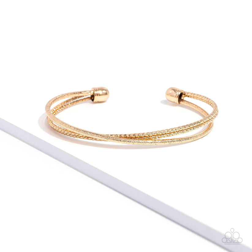 Coachella Curls - Gold Cuff Bracelet - Paparazzi Accessories - One strand of glittery gold and one double strand of textured gold crisscross across the wrist, coalescing into a versatile cuff around the wrist. Sold as one individual bracelet.