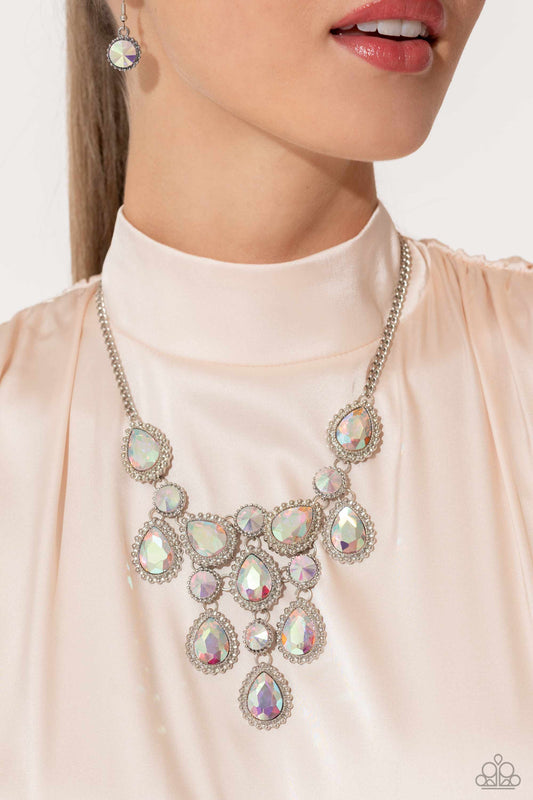 Dripping in Dazzle - Multi Iridescent Necklace - Paparazzi Accessories - An explosion of round, teardrop, and marquise-cut gems in varying sizes bordered by tactile silver studs cluster together to create a glittery iridescent showcase down the neckline. Featuring various shades of iridescence, each gem reflects light off of its faceted surface emitting further glitz and glam.