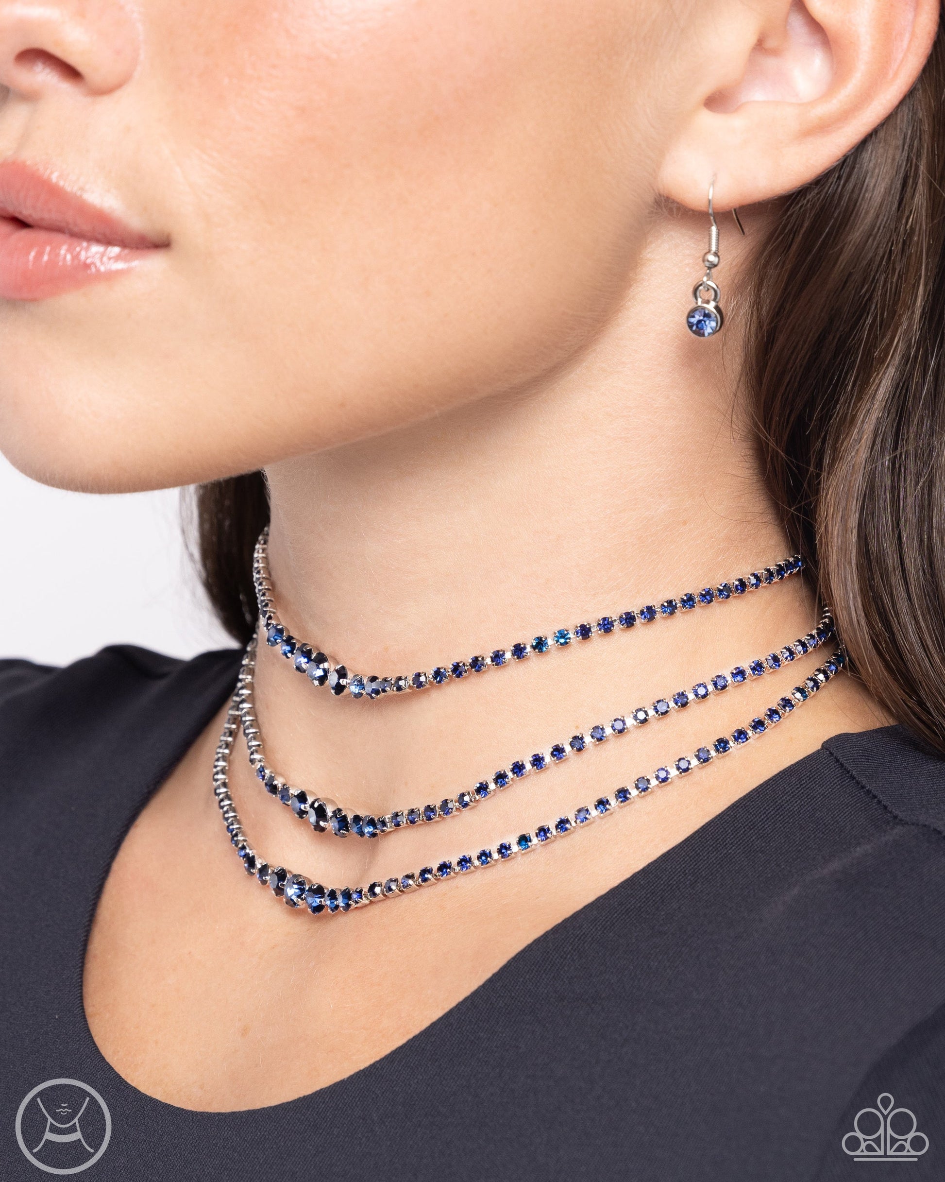 Dynamite Debut - Blue Gem Necklace - Paparazzi Accessories - Set in pronged square silver fittings, blue rhinestones gradually increase to larger blue gems in pronged fittings as they cascade down the chest in a trio of layers for a dynamite display.