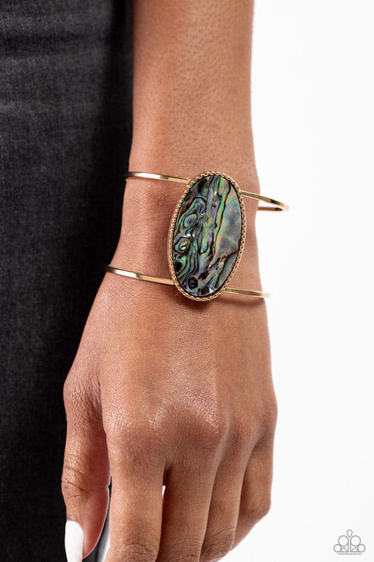 Enigmatic Energy - Gold Cuff Bracelet - Paparazzi Accessories - Featuring a faux abalone shell center, a textured gold oval frame sits atop an airy gold cuff for a seasonal look. Sold as one individual bracelet.