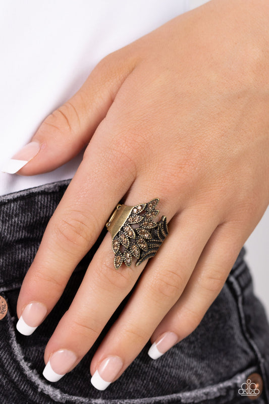 Fearlessly Feathered - Brass Topaz Rhinestone Ring - Paparazzi Accessories - Golden topaz rhinestone dotted frames delicately overlap with a fan of textured brass feathers, layering into a prismatic plume across the finger.