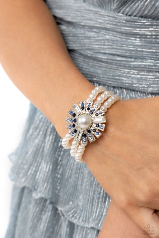 Gifted Gatsby - Blue Rhinestones and Pearl Bracelet - Three bands of pearls wrap around the wrist. Featured atop the pearly collection, sleek metal bars flare out from a mesmerizing pearl center, creating a stacked blue and white rhinestone-encrusted fringe of fanning frames. A trio of emerald-cut white gem bars are sprinkled across the dazzling display for a sassy finish.