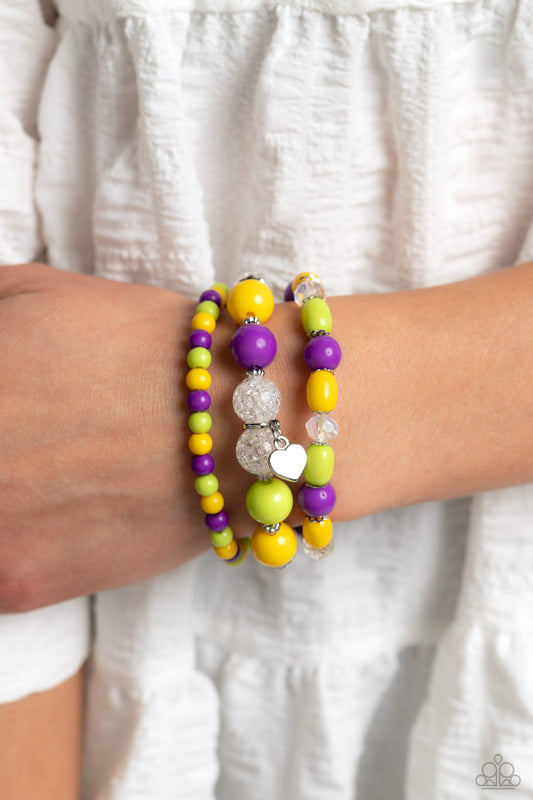Heartfelt Haven - Multi Color Bracelet - Paparazzi Accessories - Love Bird, Empire Yellow, and purple beads, silver studs and accents, clear beads that have a shattered interior, and faceted beads with a reflective finish wrap around the wrist on elastic stretchy bands for a whimsical stack. Featured on one of the bracelets, a dainty silver heart pendant dangles for a heartfelt finish to the colorful design. Sold as one set of three bracelets.