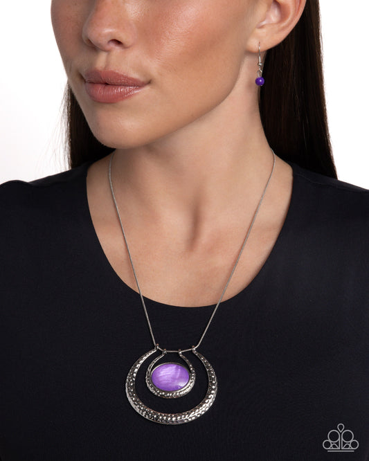 If the HORSESHOE Fits - Purple Necklace - Paparazzi Accessories - Encased in a sleek silver frame, an oval lavender shell rests horizontally at the bottom of a curved silver hammered bar, creating a half moon frame at the bottom of a sleek silver snake chain. A larger, curved, half moon frame with a hammered sheen layers below the shell-lined smaller frame for additional eye-catching detail.