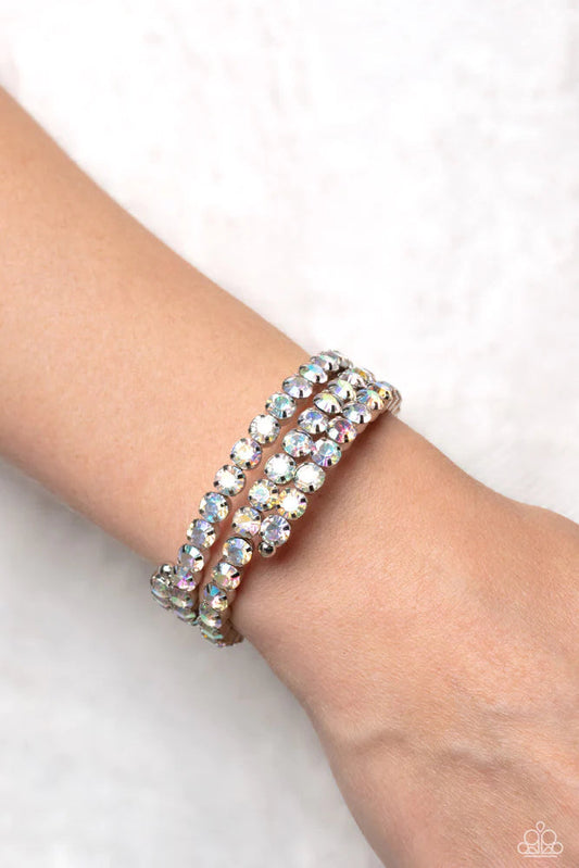 Iridescent Incantation - Multi Bracelet - Paparazzi Accessories - Three glistening rows of iridescent gems, pronged in place by silver fittings, curl along a coiled wire, creating a blinding infinity wrap style bracelet around the wrist.