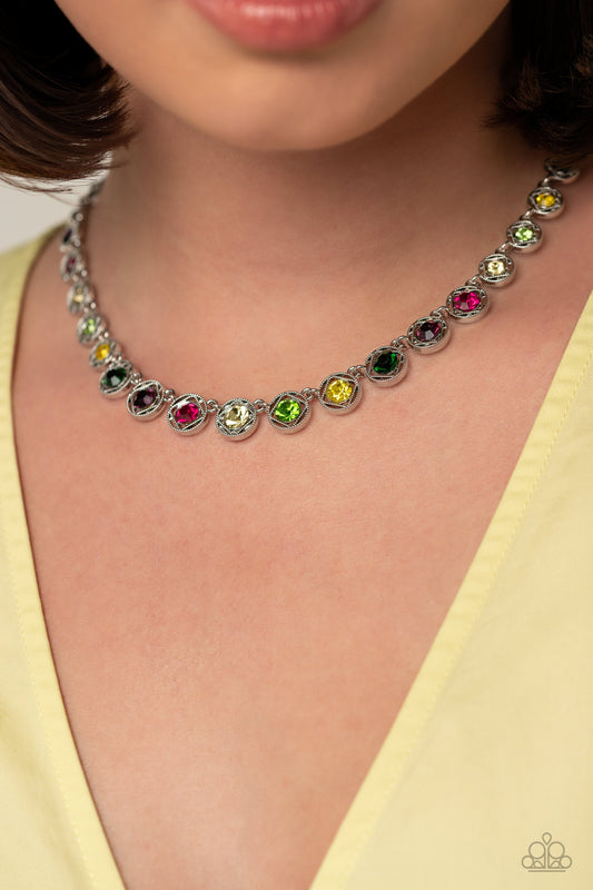 Kaleidoscope Charm - Multi Color and Silver Necklace - Paparazzi Accessories - Spanning around the entirety of the neckline, a refined collection of colorful rhinestones are pressed into airy, studded, silver square frames, tilted on their sides for a three-dimensional shimmer. The frames and rhinestones gradually increase in size as they fall down the neckline, accentuating their colorful sparkle.