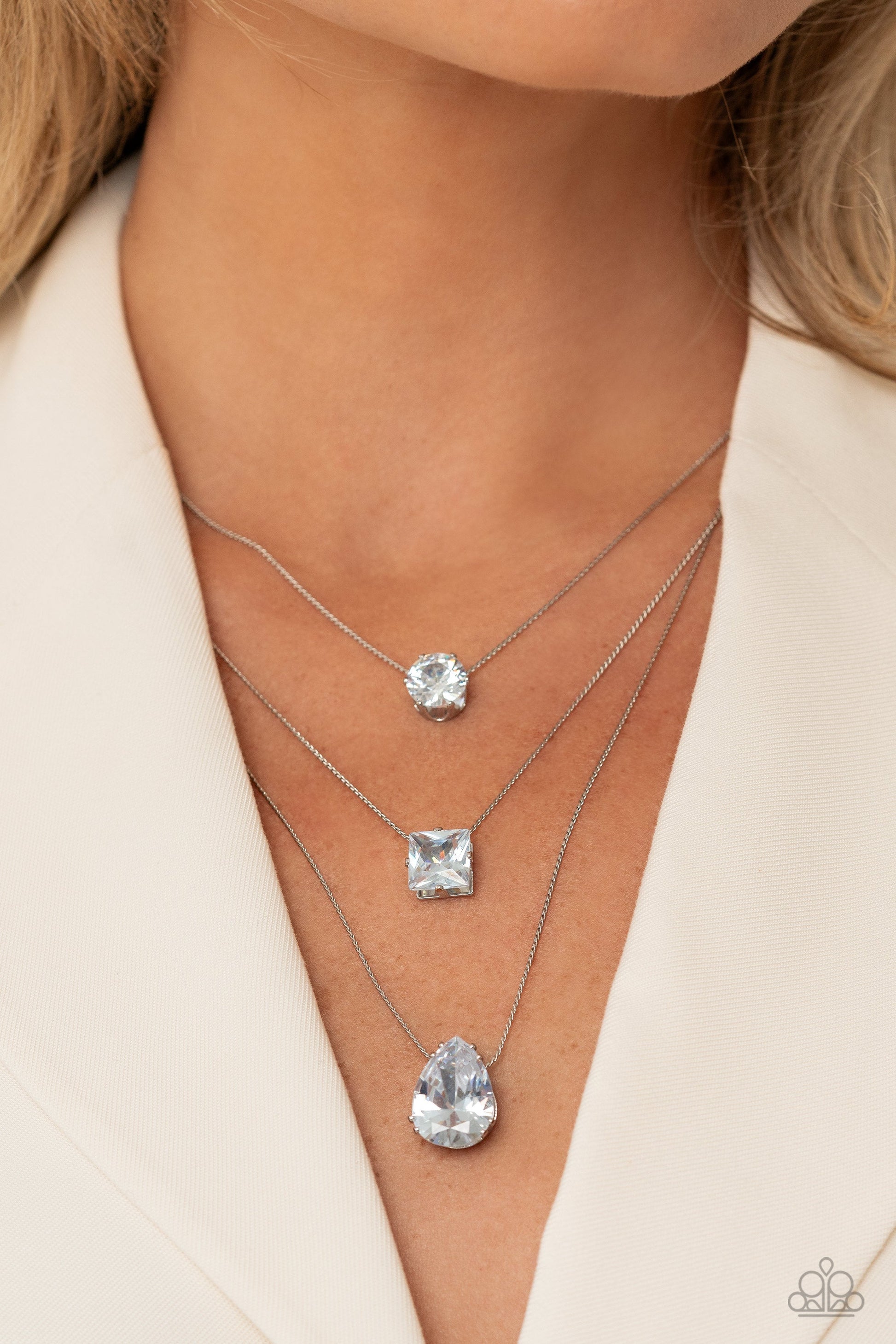 Lustrous Layers - White and Silver Necklace - Paparazzi Accessories - Featuring a subtle iridescent finish, exaggerated, faceted round, square, and teardrop gems layer down the chest from three sleek silver dainty chains, in a refined fashion.
