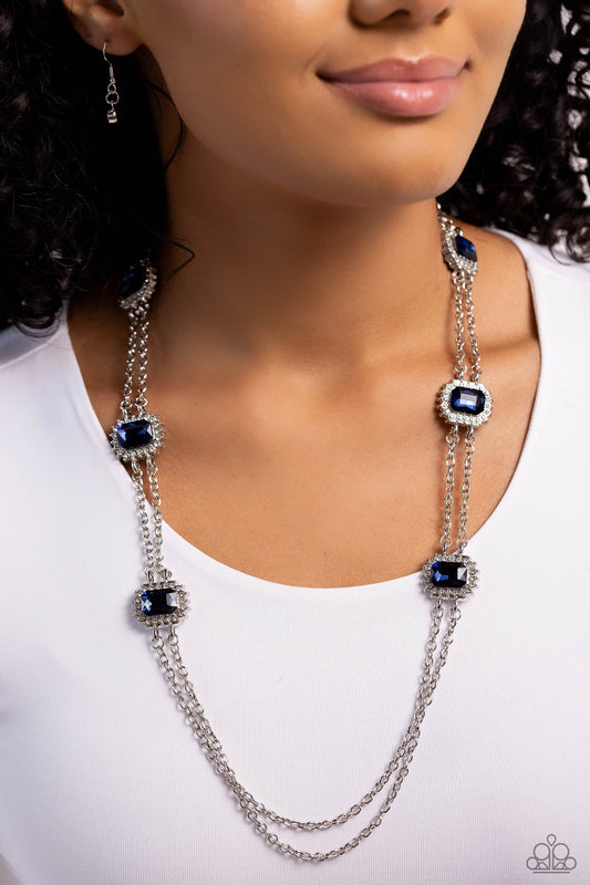Pocketful of Sunshine - Blue and Silver Necklace  - Paparazzi Accessories - Pressed in sunburst-like, rhinestone-encrusted pronged silver fittings, a collection of emerald-cut blue gems are infused between a double-strand of silver chains for a standout statement.