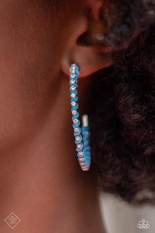 Put a STRING on It - Blue and Silver Hoop Earrings - Paparazzi Accessories - The outer edge of an oversized silver hoop is lined with classic white rhinestones, scattering sparkle in every direction. A strand of blue cording intricately twists and weaves in between the glitzy gems, adding a fearless pop of color to the design. Earring attaches to a standard post fitting. Hoop measures approximately 2″ in diameter. Sold as one pair of hoop earrings.