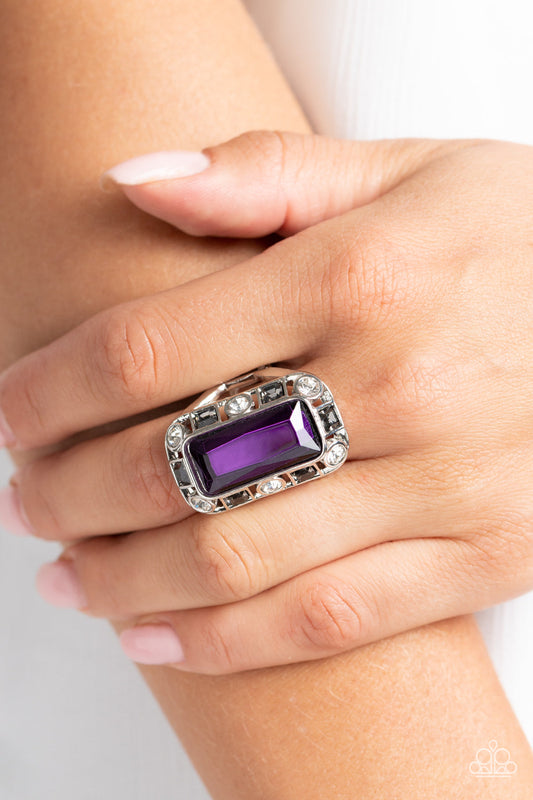 Radiant Rhinestones - Purple and Silver Ring - Paparazzi Accessories - Pressed into a curved, rectangular silver frame, an oversized emerald-cut purple gem shines atop the finger. Dainty square and round gems in shades of white and smoky black airily encircle the oversized gem for some additional shimmer resulting in a radiant centerpiece ring.