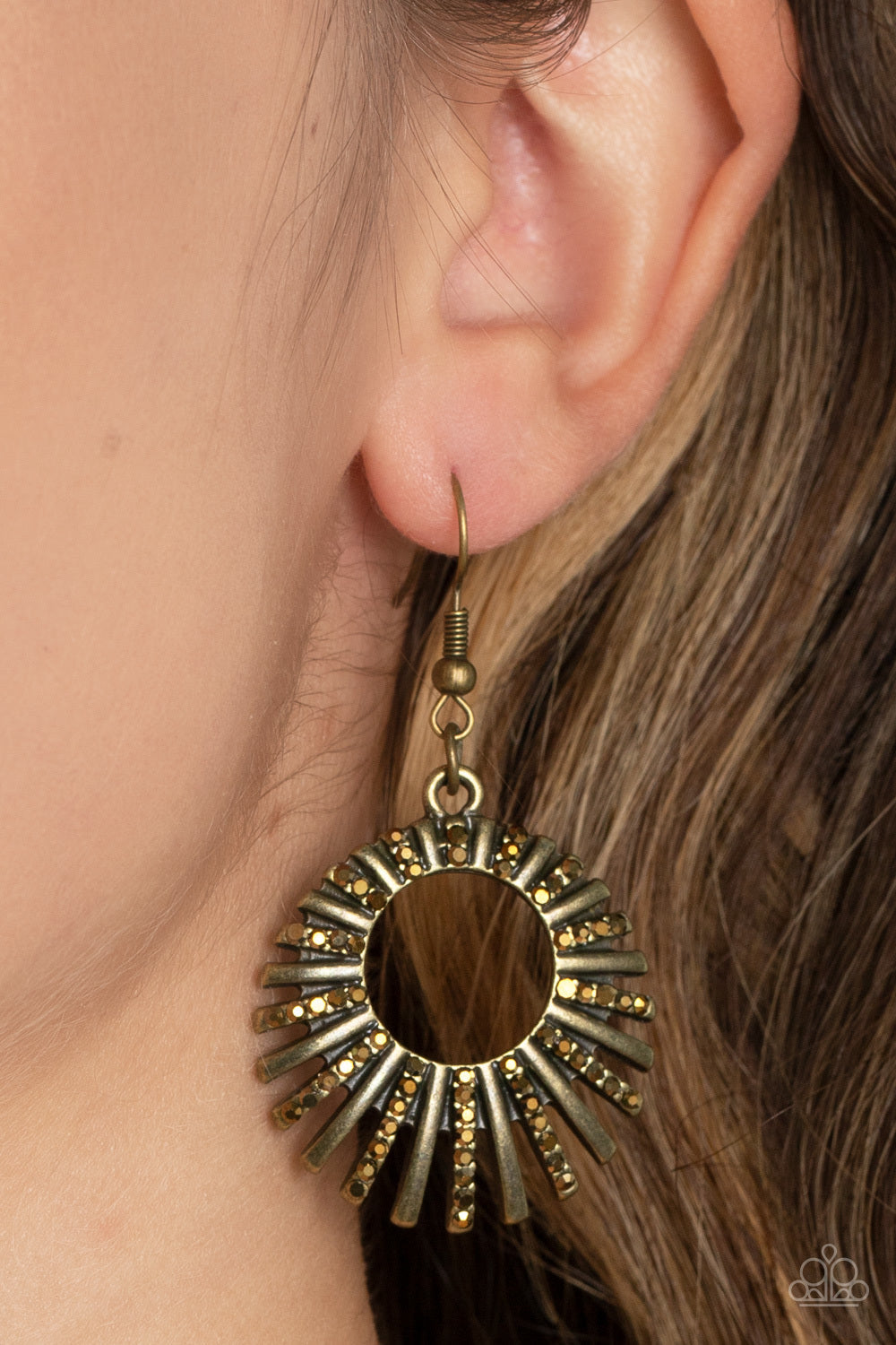 Rebel Resplendence - Brass Earrings - Paparazzi Accessories - Pressed into studded brass fittings, a collection of glittery aurum rhinestones collect inside of a hoop of brass bars, creating a sparkling frame. Earring attaches to a standard fishhook fitting. Sold as one pair of earrings.